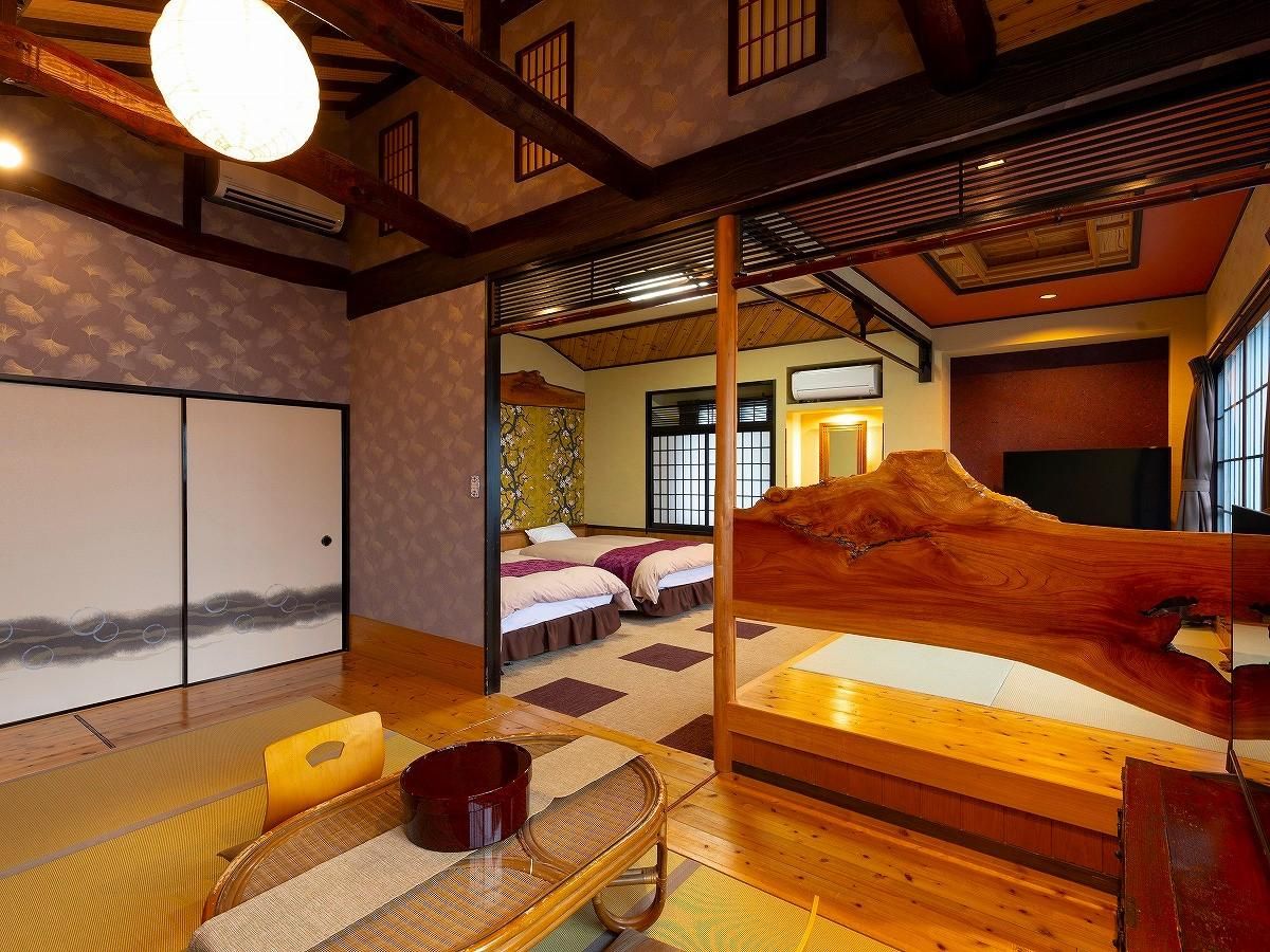 Una habitación tradicional japonesa con suelo de tatami, una cama de madera baja y una puerta corredera.