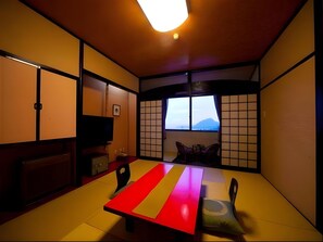A traditional Japanese room with tatami flooring, a low table, and sliding doors.