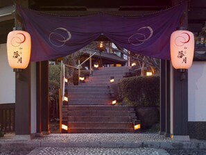 A traditional Japanese entrance with a staircase leading up to a building, adorned with hanging lanterns and a purple canopy. - Nagomi no Yado Mutsuki (Beppu)