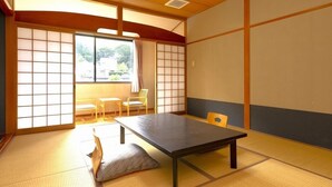 Een traditionele Japanse kamer met tatami vloeren, een lage tafel en schuifdeuren.