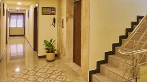 Un pasillo de hotel con piso estampado, una escalera y una planta en maceta.