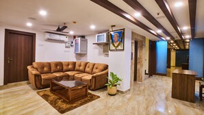 Una sala de estar moderna con un sofá modular, una mesa de centro, una planta en maceta y un ventilador de techo.