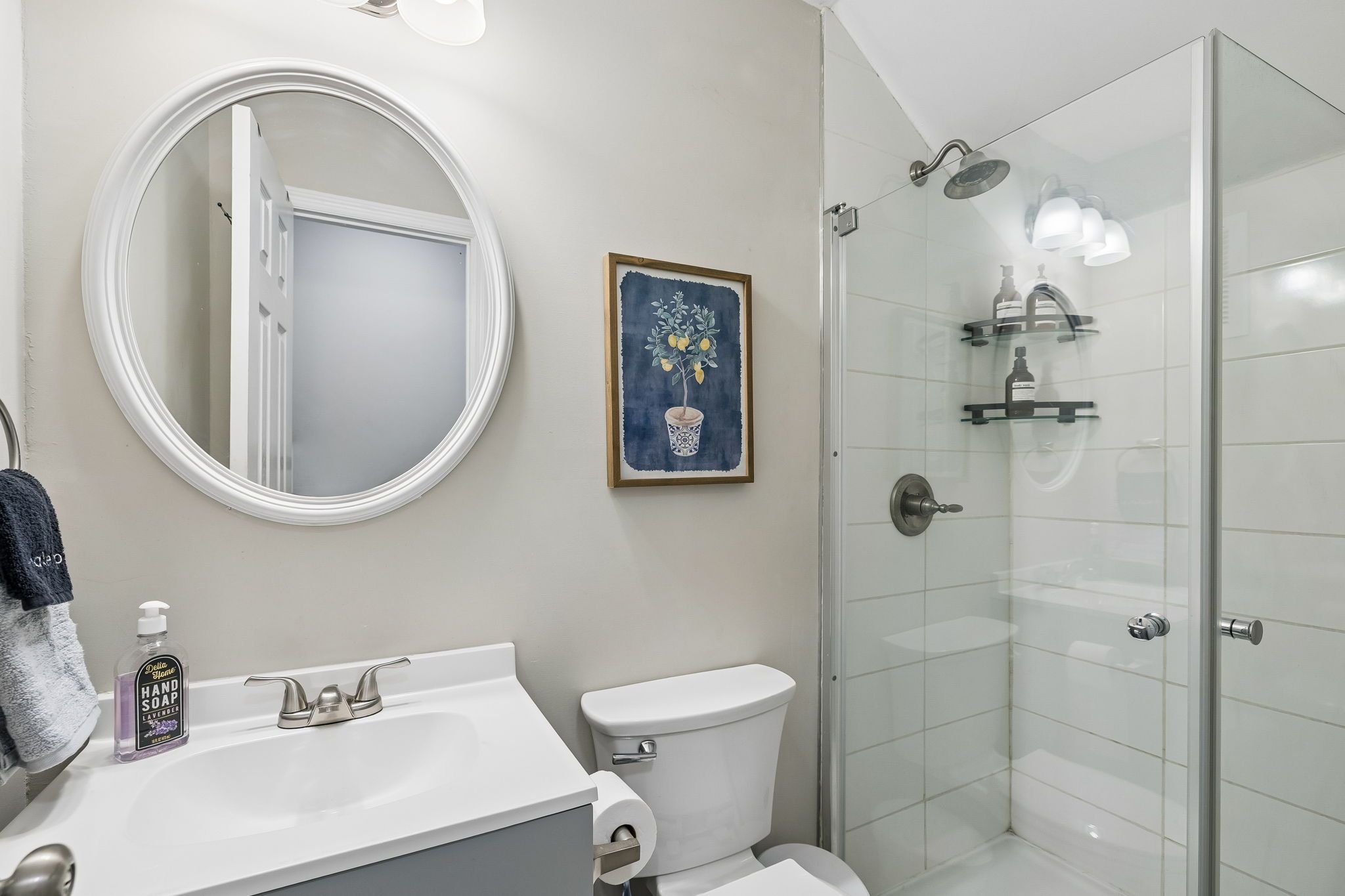 Un baño con inodoro, lavabo, espejo y ducha.