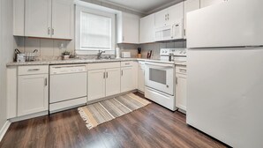 A modern kitchen with white cabinets, a built-in oven, microwave, and refrigerator. - Cute Modern Townhouse Close to MTSU, Parks & Downtown: Large Master & Coffee Bar (Murfreesboro)