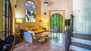 A cozy living room with a sofa, armchairs, a coffee table, and a TV. - Casa Paraiso - Tropical Private Pool Near Beach (Esterillos Oeste)