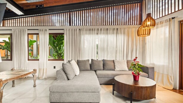 Una sala moderna con un sofá modular, una mesa de centro redonda y un banco de madera.