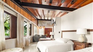 A hotel room with a wooden ceiling, a sofa, two beds, a nightstand, and a lamp. - Welcome to Paradise - Luxurious Studio Oasis `Urania` with Pool and Lush Tropical Gardens (Sayulita)