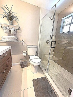 A modern bathroom with a toilet, a shower enclosure, and a sink. - Beautiful And Comfortable Home and studios   (Miami)
