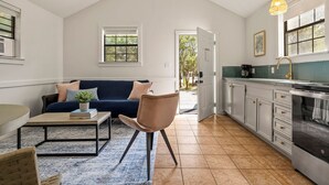 A modern kitchen with a dining area, a sofa, and a chair.