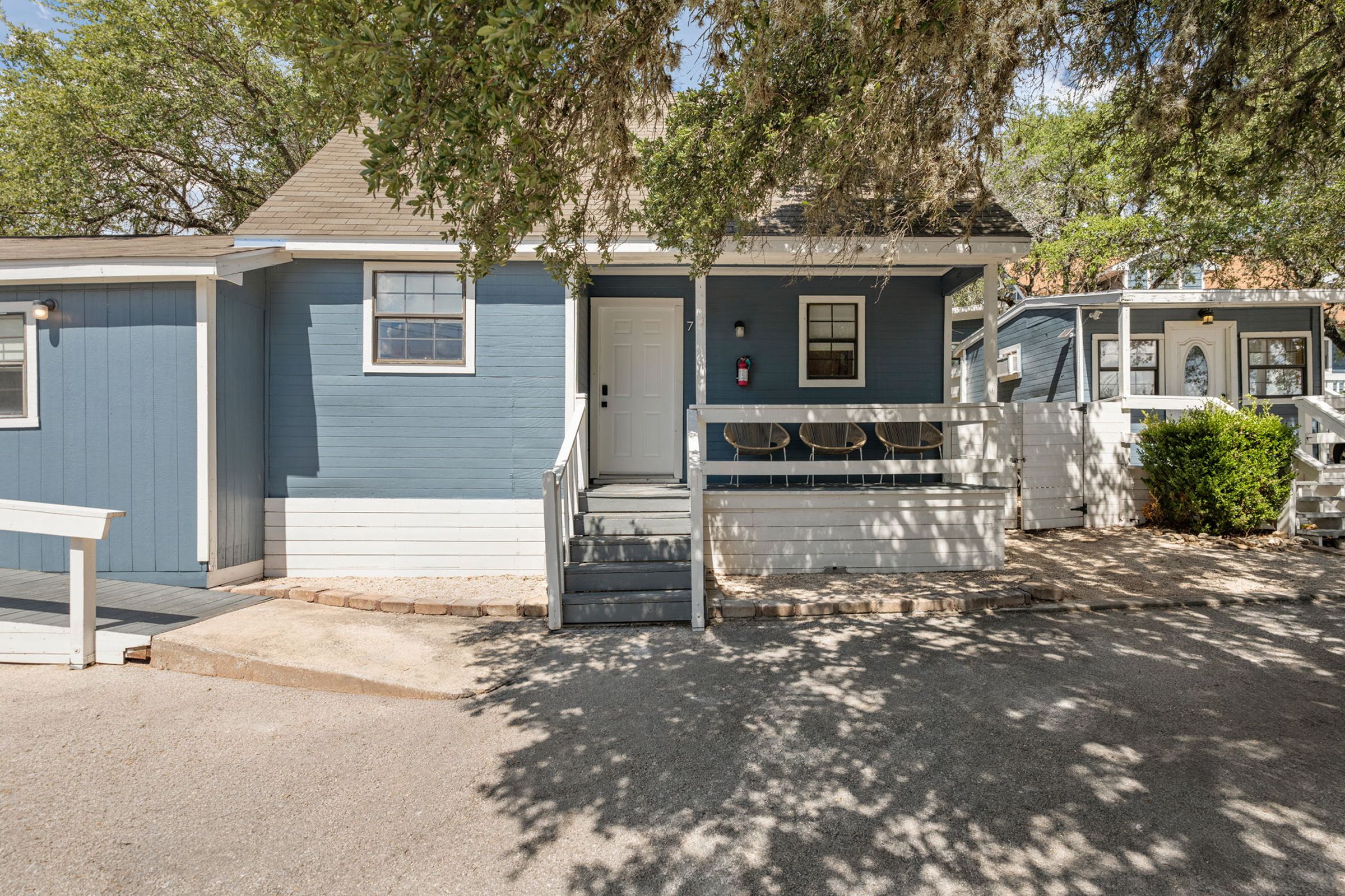 A small, single-story building with a front porch, a door, and a window.