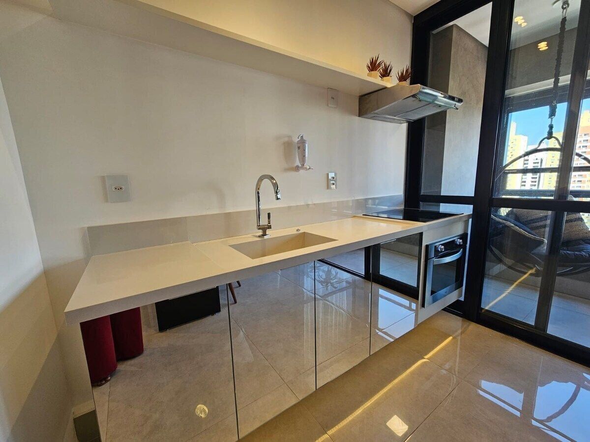 Una cocina moderna con una isla grande, electrodomésticos de acero inoxidable y vistas a la ciudad a través de amplios ventanales.