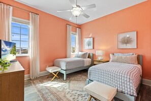 A bedroom with two beds, a ceiling fan, a TV, and a window with curtains. - New Beachcombers @ Luxurious Cinnamon Cove w/ Pool (Palm Coast)