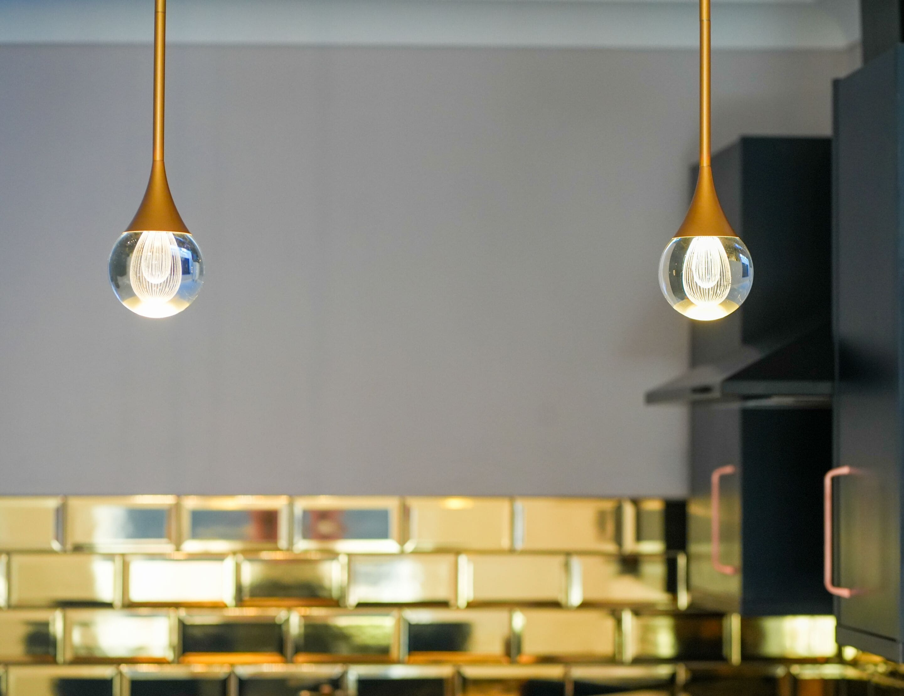 Twee hanglampen met een bolvormig ontwerp, bevestigd aan het plafond.