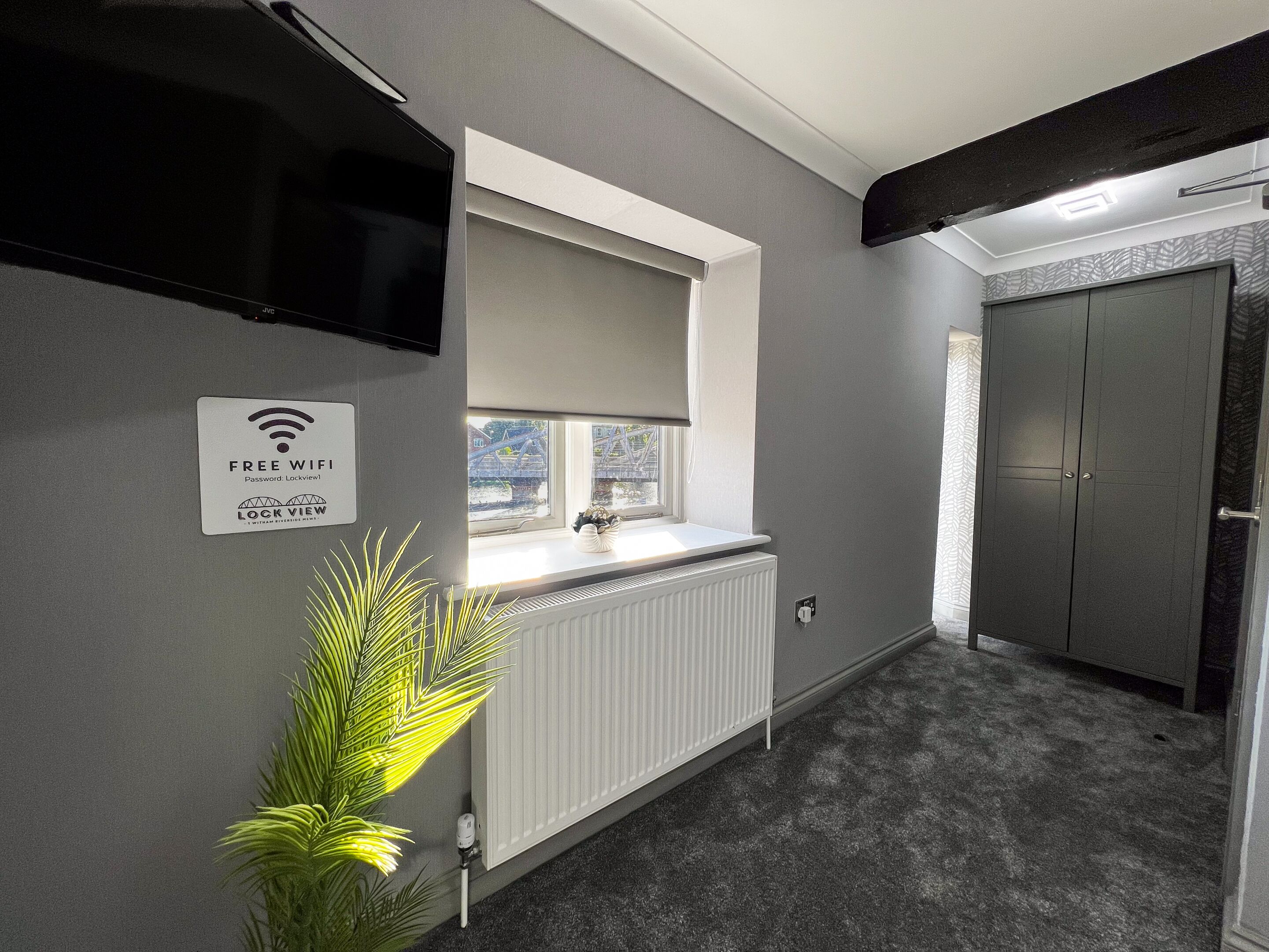Een moderne badkamer met een inbouwwastafel, een handdoekhouder, een radiator en een deur met een handgreep.