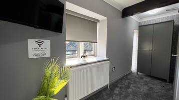 Een moderne badkamer met een inbouwwastafel, een handdoekhouder, een radiator en een deur met een handgreep.