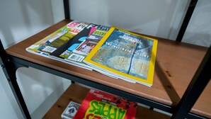En hylla med olika tidskrifter och en bok med titeln ”Den ultimata klättringen”.