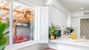 A modern kitchen with white cabinets, a microwave, and a sink.