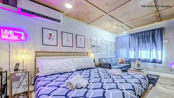 A modern hotel room with a large bed, a desk, and a window with curtains.