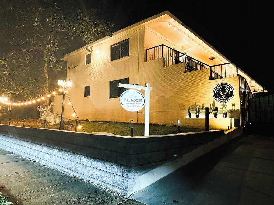 A two-story building with a sign indicating it is "The Moose Apartments."