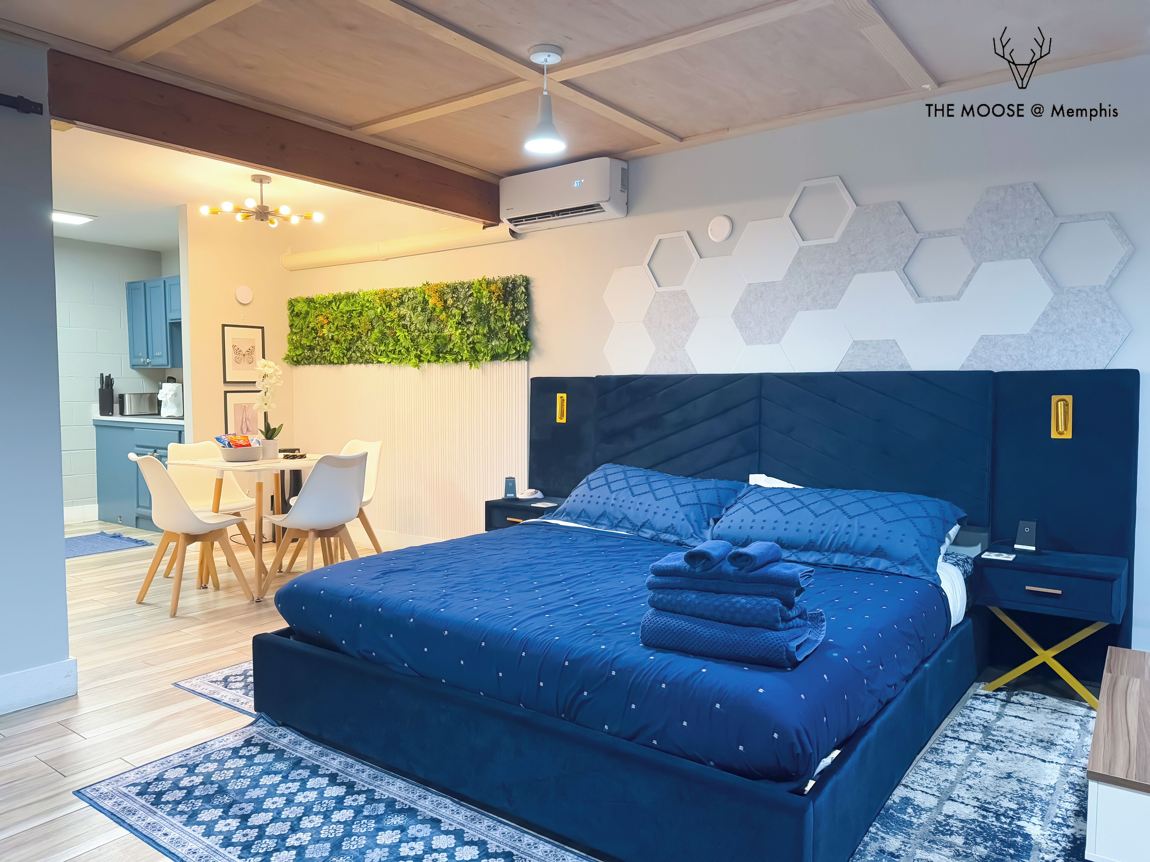 Une chambre d’hôtel moderne dotée d’un grand lit, d’un bureau et d’une kitchenette.