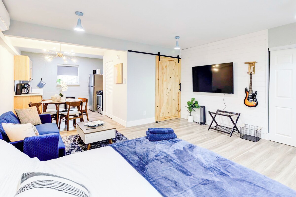 Una sala de estar moderna con un sofá, una mesa de centro y un televisor montado en la pared.