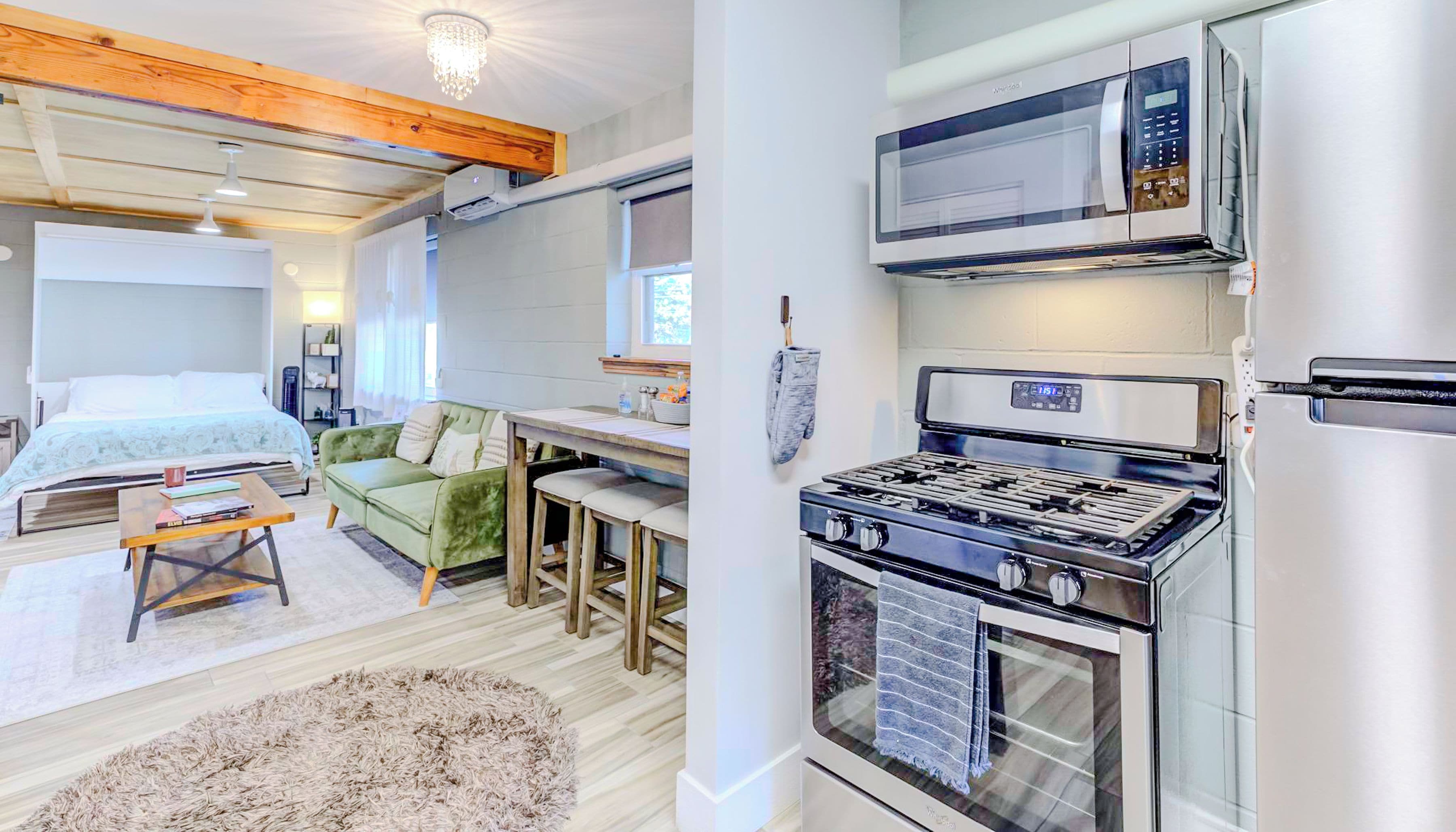 A modern kitchen with a stove, microwave, and refrigerator.
