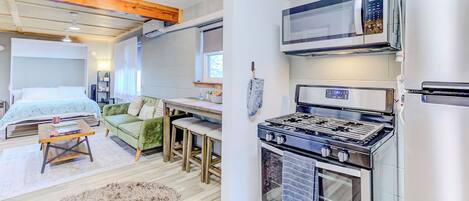 A modern kitchen with a stove, microwave, and refrigerator.