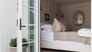 A bedroom with a bed, a window, and a potted plant. - New! Beautiful Beach House Steps from Sunset Cliffs!  (San Diego)