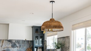 A modern kitchen with a marble backsplash, wooden chairs, and a large window. - New! Beautiful Beach House Steps from Sunset Cliffs!  (San Diego)