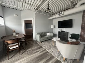 Relax in this stylish living space with a dining area, sofa, and armchair.