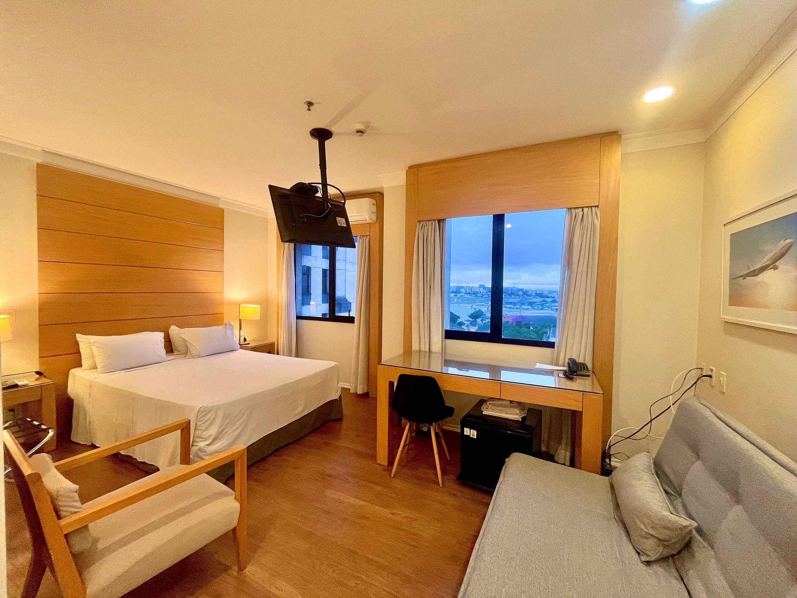 Habitación de hotel con cama, escritorio y zona de estar.