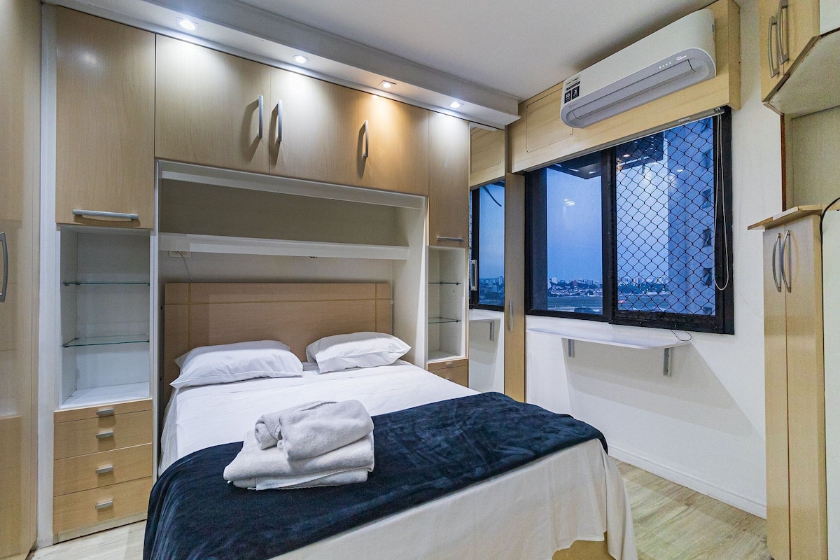 Un dormitorio con cama, armario empotrado y ventana con vistas.