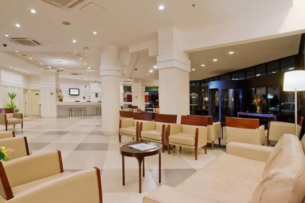 Un hall de hotel con mostrador de recepción, zona de estar y un escritorio.