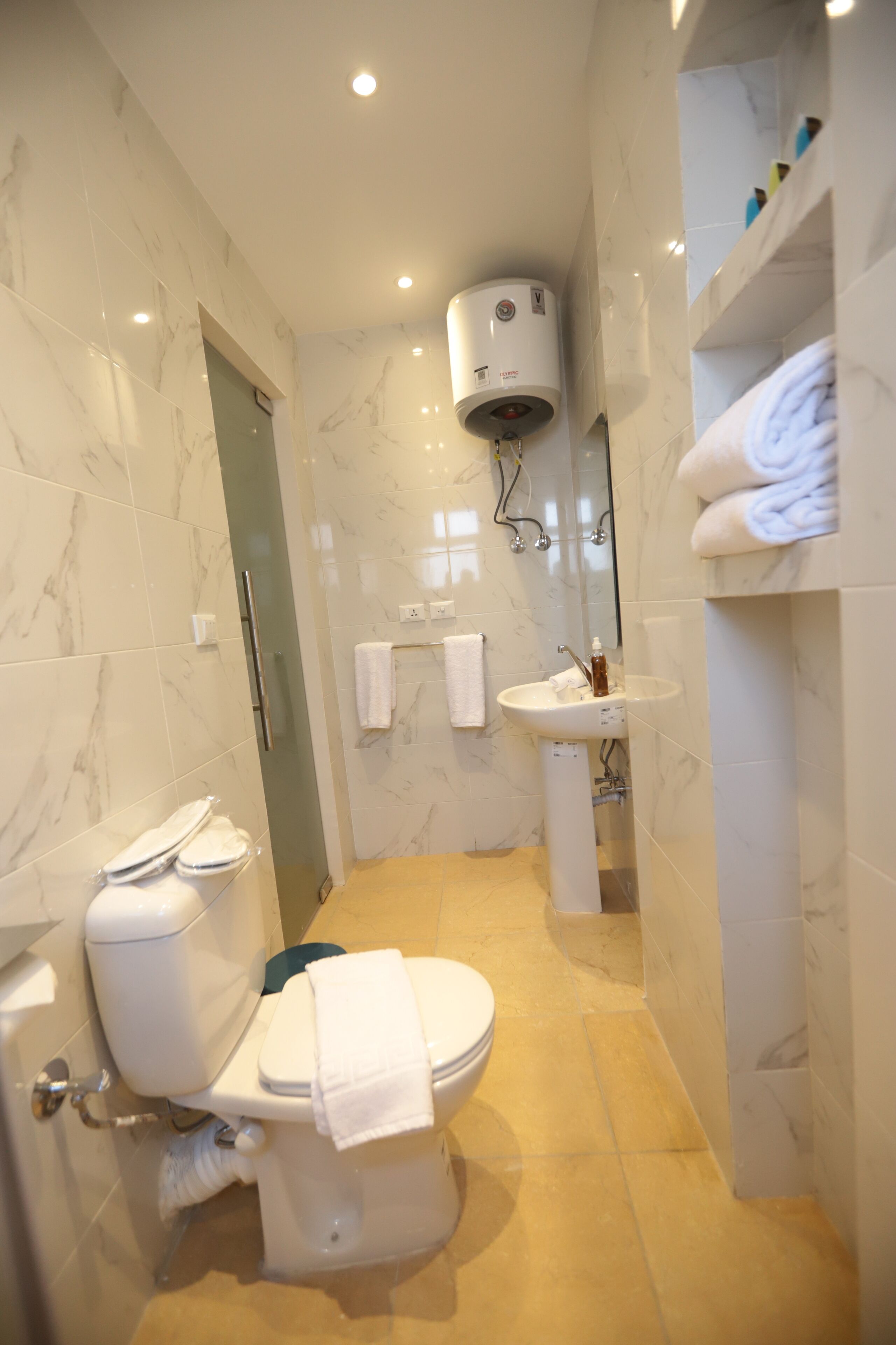 Une petite salle de bain comprenant des toilettes, un lavabo et un porte-serviettes.