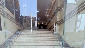 A staircase leading to a building entrance with glass railings and a marble floor. - King Khafren View INN (Giza)