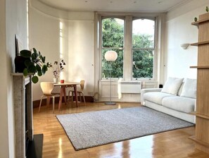 Relax in this serene space with a comfortable sofa, dining area, and natural views.