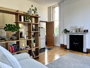 Relax in a spacious living area with a comfortable sofa, bookshelf, and fireplace.