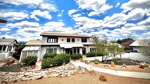 A two-story house with a large front yard, a driveway, and a garage. - Private 5 BDR Pet Friendly Mountain Villa w/ Jacuzzi minutes from Santa Fe (Rowe)