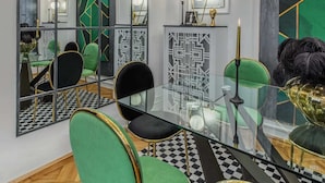 A modern dining area with a glass table, green and black chairs, and a checkered floor. - Holt - The Great Gatsby (Bucharest)