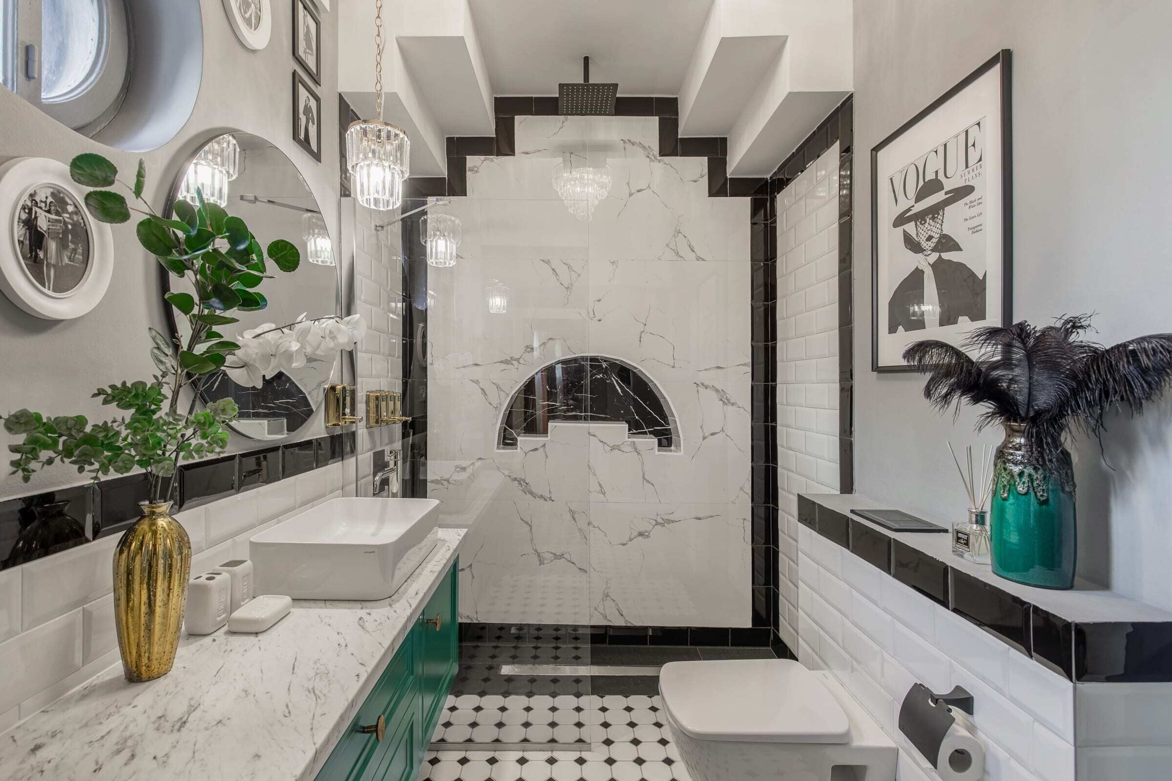 Une salle de bain moderne avec un lavabo blanc, des murs en marbre, une douche et des toilettes.