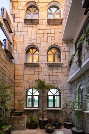 Un edificio de piedra con ventanas arqueadas y plantas en macetas.