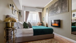 A bedroom with a bed, a TV, a fireplace, and a large painting on the wall. - Holt - Bagheera and Mowgli (Bucharest)