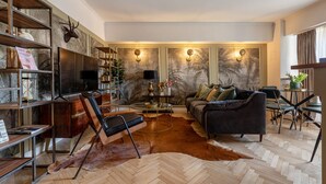 A modern living room with a leather sofa, a coffee table, and a bookshelf. - Holt - Bagheera and Mowgli (Bucharest)