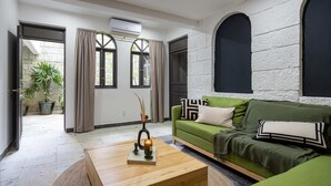 A modern living room with a green sofa, a wooden coffee table, and a potted plant. - Sleeps 9 Outdoor Space Pingpong Table in Villa (Oaxaca)