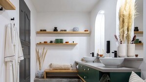 A modern bathroom with a large mirror, a sink, and a vanity. There are shelves above the mirror and a towel rack on the left. - Sleeps 9 Outdoor Space Pingpong Table in Villa (Oaxaca)