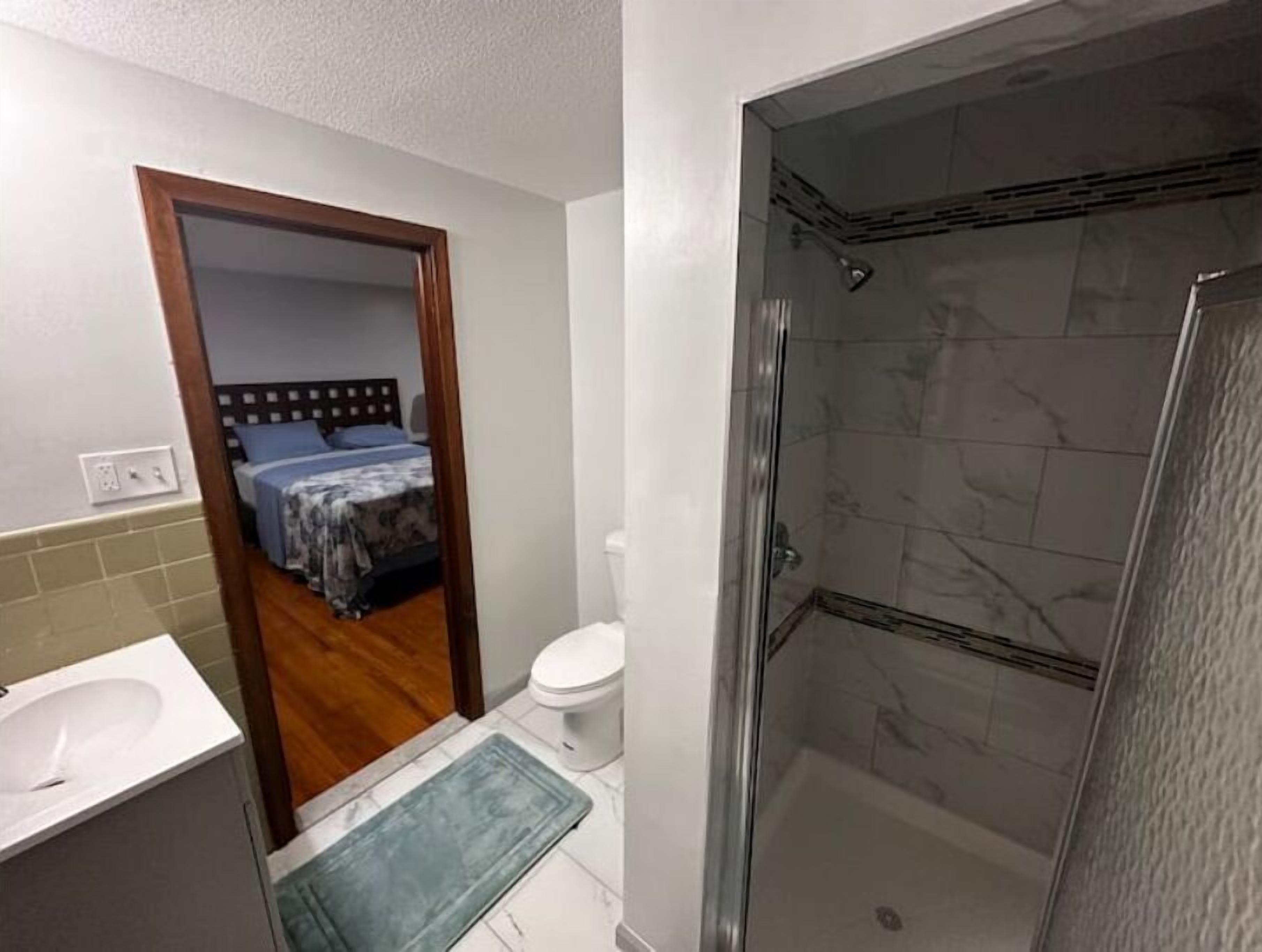 A bathroom with a shower, toilet, and sink.
