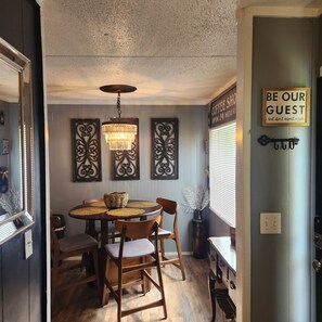 Enjoy meals in this dining area with a round table and four chairs, surrounded by decorative wall art and a chandelier.