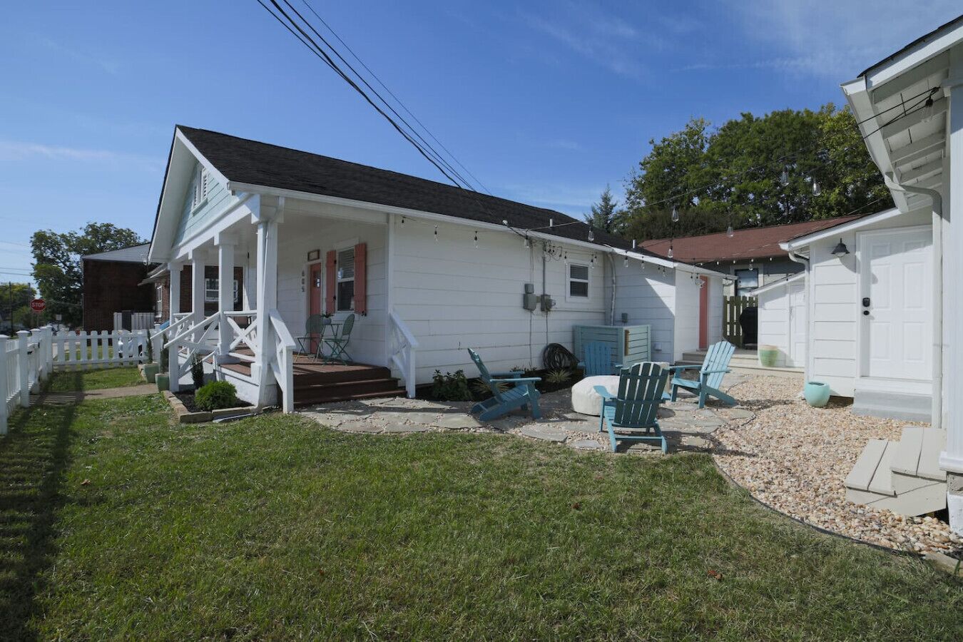 A single-story house with a porch, a small deck, and outdoor seating.
