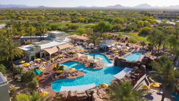 Un complexe hôtelier doté d’une grande piscine, de nombreux espaces de détente et offrant une vue sur un paysage montagneux.