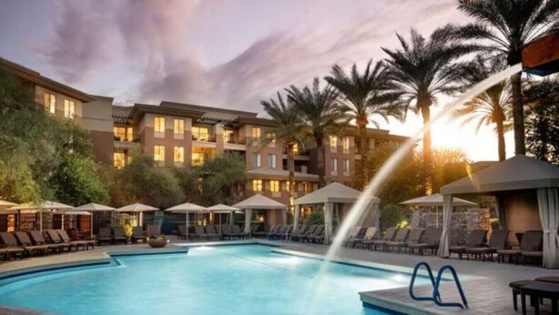A swimming pool with lounge chairs and umbrellas, surrounded by palm trees and a hotel building. - The Westin Kierland Villas (2 Bedroom) (Scottsdale)